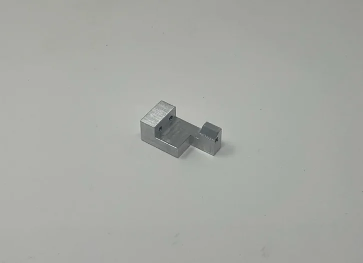 A metal object sitting on top of a white surface.