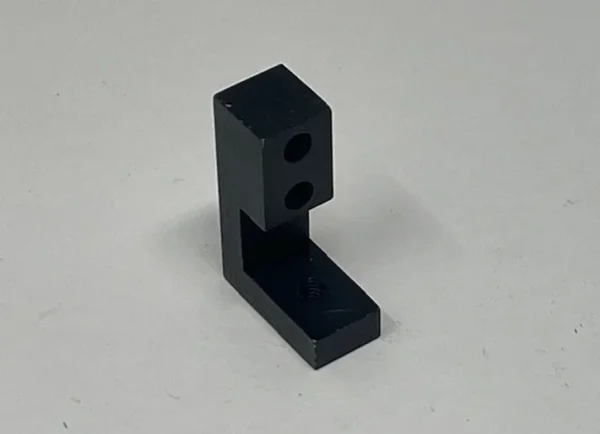 A black plastic block with two holes.