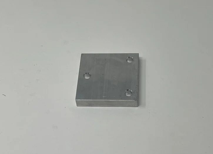 A metal plate with two holes on top of it.