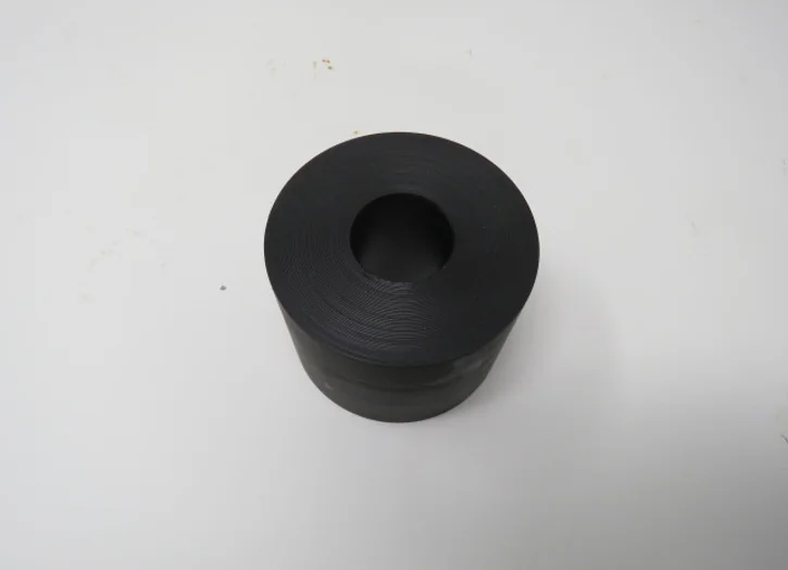 A black rubber bushing sitting on top of a table.