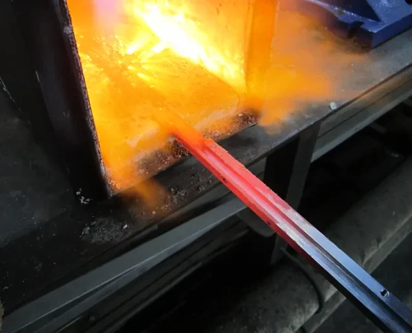 A glass blowing machine is being used to produce the colors of the flag.