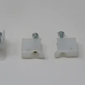A white wall with three different types of clips.