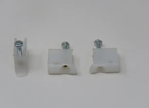 A white wall with three different types of clips.