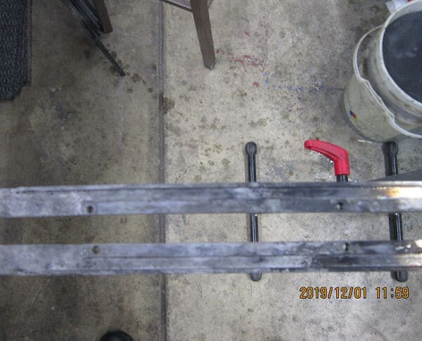 A pair of wrenches sitting on top of a wooden rail.