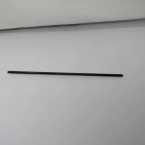 A black rod is sitting on top of the table.