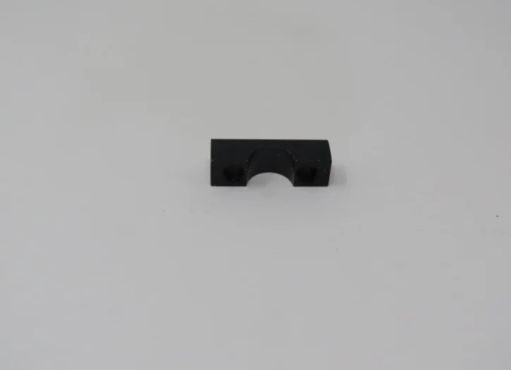 A black piece of plastic sitting on top of a white surface.