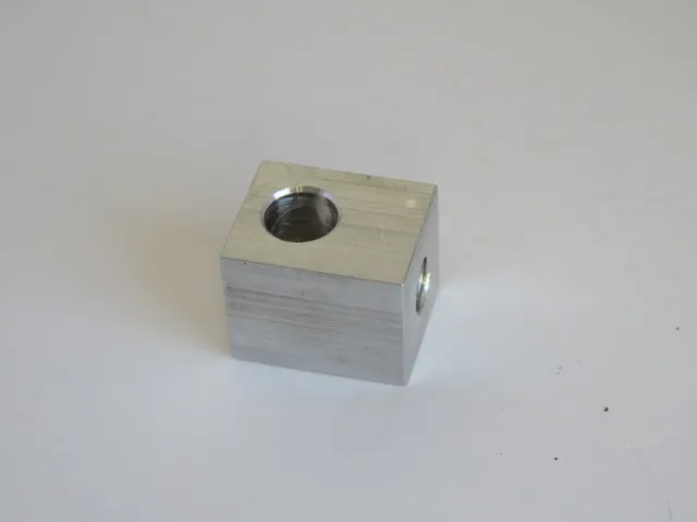 A metal block with one hole in it.